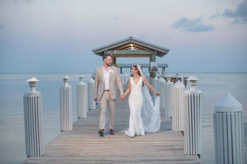 Bride and groom walking hand in hand on the dock at Cheeca Lodge in Islamorada
