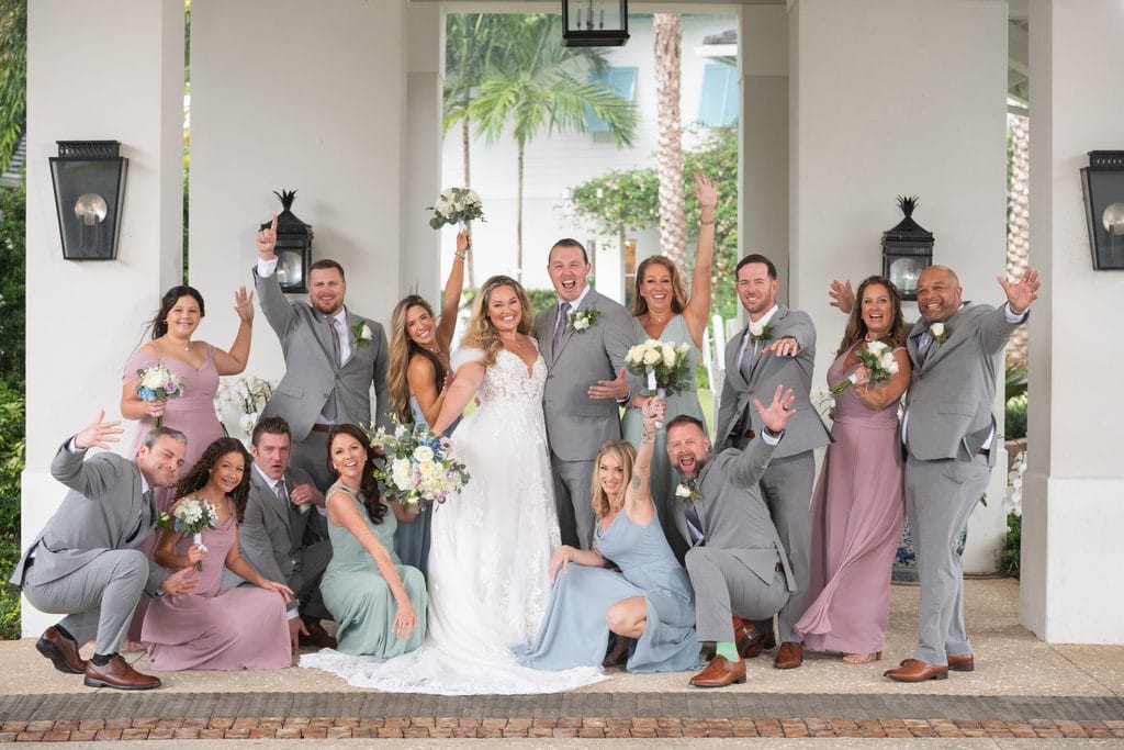 Amanda and Trevor cheering with their wedding party on the Pelican Club's covered terrace. 